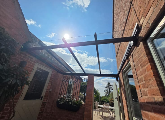Modern glass veranda over patio on brick house, sunny.